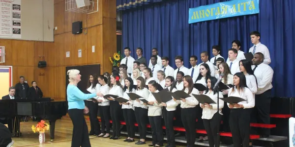 Choir performing on stage with conductor directing.