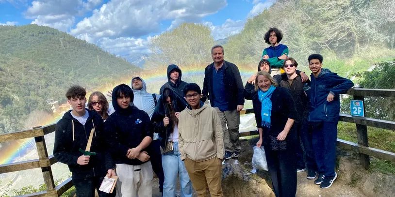 Group posing by scenic mountain view.